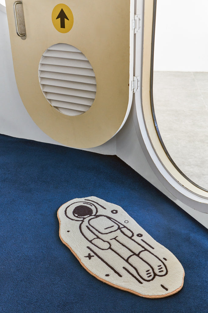 white-and-black-astronaut-rug-on-blue-carpet